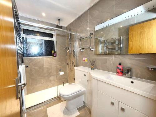 uma casa de banho com um WC, um chuveiro e um lavatório. em Gilpin villa 4Bedroom WiFi, Parking, Netflix, Garden em Gloucester