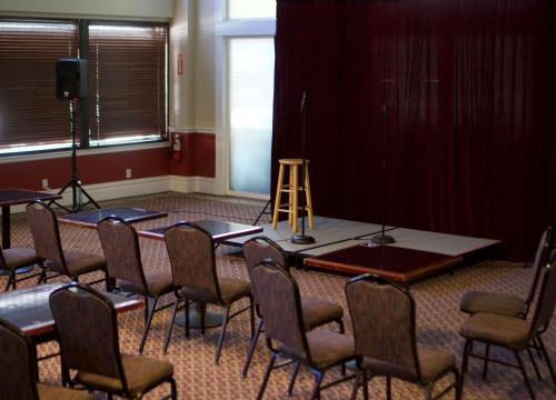 a room with a table and chairs and a stage at The Washington Inn in Oakland