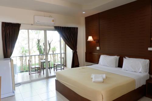 um quarto com uma cama grande e uma varanda em กิจตรงวิลล์ รีสอร์ท Kittrongvill em Ubon Ratchathani
