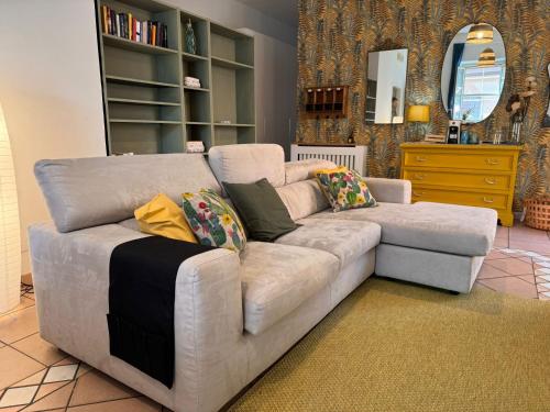 un sofá blanco con almohadas en la sala de estar en La Casa di Via Nervi, en Ladispoli