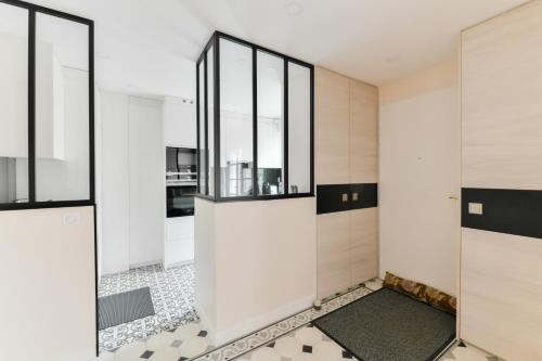 ein Badezimmer mit Glastüren und Fliesenboden in der Unterkunft Maison avec terrasse privée in Versailles