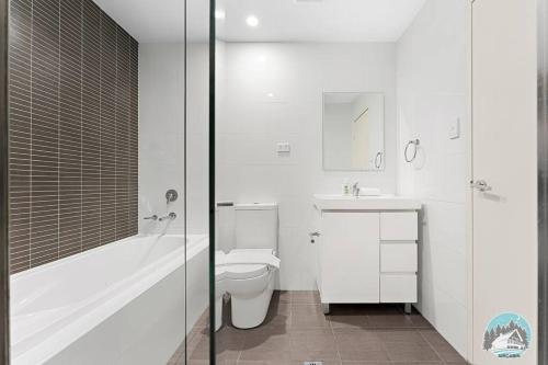 a bathroom with a toilet and a tub and a sink at Aircabin - Mascot - Walk to Station - 3 Beds Apt in Sydney