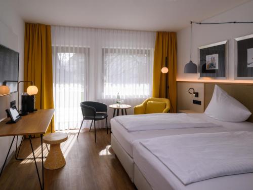 Habitación de hotel con cama, mesa y sillas en Hotel Schnitterhof en Bad Sassendorf
