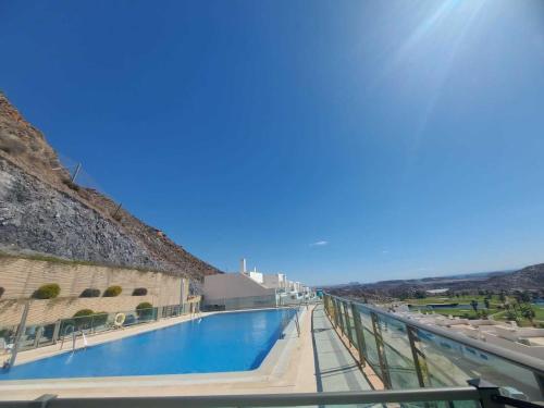 vistas a la piscina desde el balcón de un edificio en La Perla Verde apartment on Aguilón GolfPulpí, en Pilar de Jaravía
