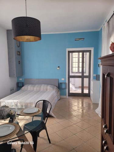 Habitación azul con cama y mesa en La Vecchia Riseria 2, en Novara