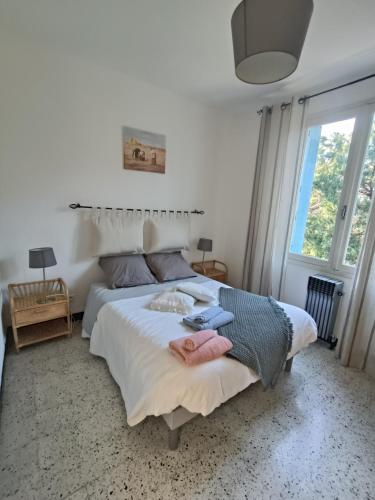 une chambre avec un lit avec deux serviettes dessus dans l'établissement A l'ombre de l'olivier, à Orgon