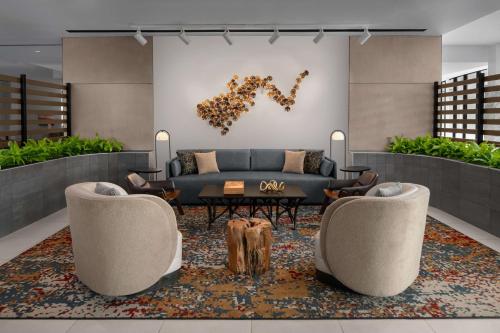 a living room with a couch and two chairs at Hilton Garden Inn Grand Prairie At EpicCentral in Grand Prairie