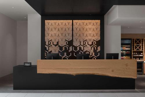 a lobby with a reception desk with a patterned wall at Hilton Garden Inn Grand Prairie At EpicCentral in Grand Prairie