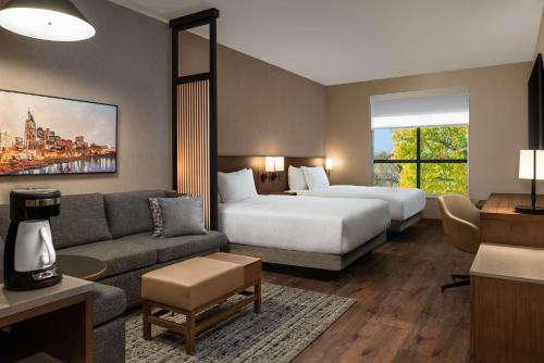 a hotel room with a bed and a couch at Hyatt Place Nashville/Green Hills in Nashville