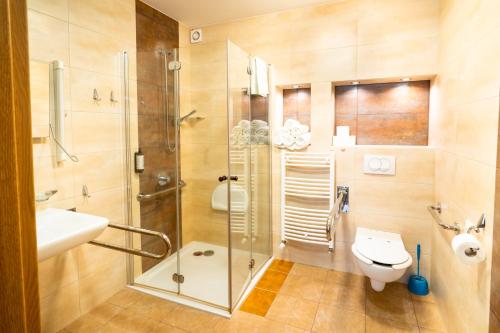 a bathroom with a shower and a toilet and a sink at Ośrodek Szkoleniowo-Wypoczynkowy "Leśnik" in Ustka