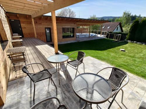 a patio with chairs and tables on a deck at Švihák lázeňský in Velké Losiny