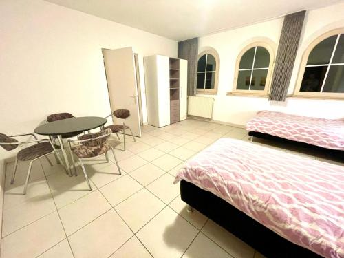 アルセンにあるApartment Maasheuvelのベッドルーム1室(ベッド1台、テーブル、テーブル付)