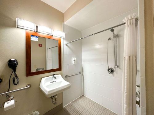 uma casa de banho com um lavatório e um chuveiro com um espelho. em Country Inn & Suites by Radisson, Rock Falls, IL em Rock Falls