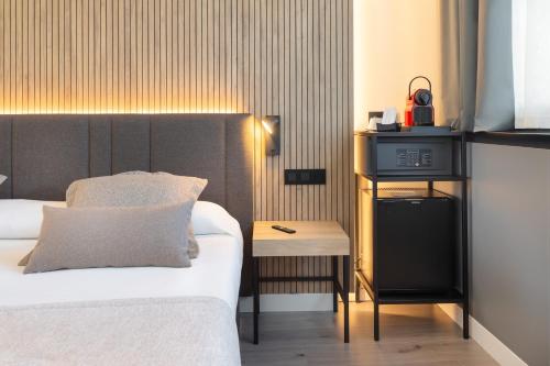 a hotel room with a bed and a table with a night stand at Alexandre Fira Congress in Hospitalet de Llobregat