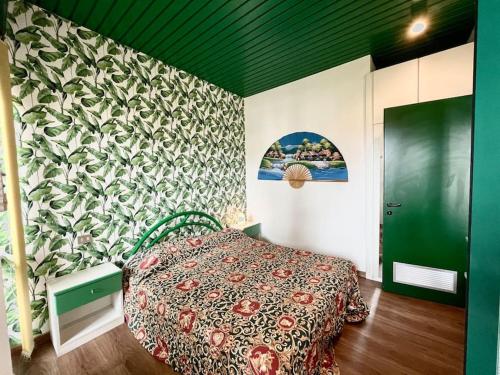 a bedroom with a bed and a green wall at MiniJungleSuite close to the Sea in Cinquale