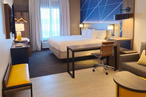 Comfort Inn & Suites at Sanford Sports Complex في شلالات سيوكس: غرفة في الفندق مع سرير ومكتب