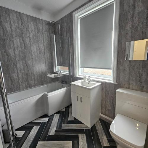 a bathroom with a tub sink and a toilet at Lyndhurst Terrace, Sunderland in Trimdon Grange