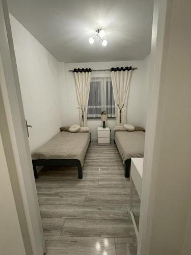 a room with two beds and a window at Apartament na Miłej in Kostrzyn nad Odrą