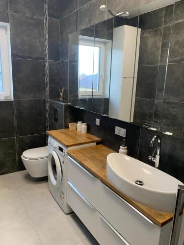 a bathroom with a sink and a washing machine at Apartament na Miłej in Kostrzyn nad Odrą