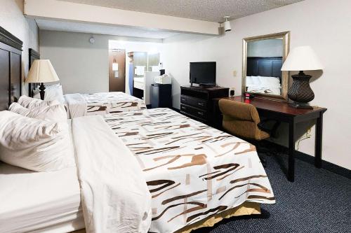 Habitación de hotel con 2 camas y escritorio en Rodeway Inn, en Helena