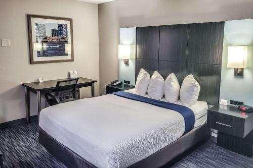 Habitación de hotel con cama grande y escritorio. en Quality Inn Southside Jacksonville en Orange Park