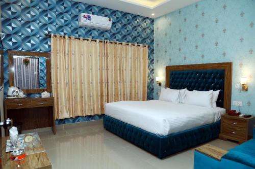 um quarto com uma cama e uma parede azul em Hotel Grand Pearl em Lahore