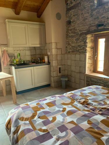 a kitchen with a large bed in a room at Alte terre - Lab&room in San Damiano Macra