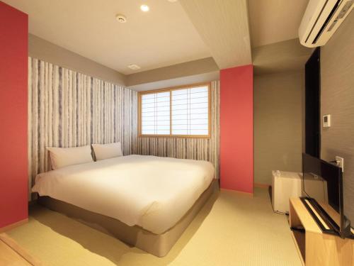東京的住宿－淺草旅籠酒店，卧室配有白色的床和红色的墙壁