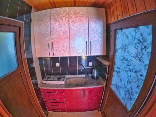 UZUNGÖL ADİLOGLU SUIT في أوزونغول: مطبخ صغير مع حوض ونوافذ