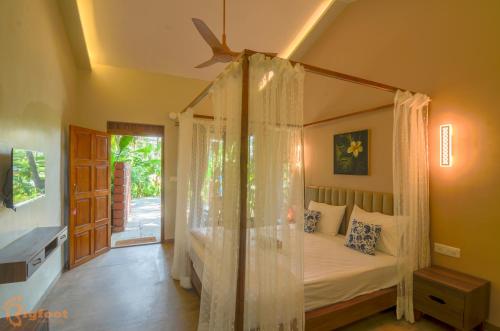 um quarto com uma cama de dossel e uma casa de banho em Jomo Resort em Alibag