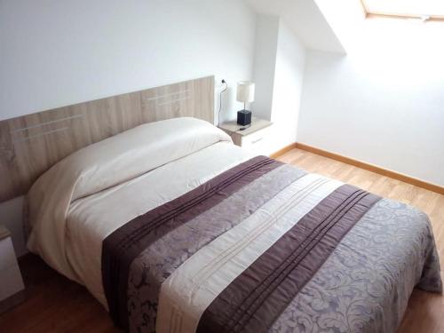 um quarto com uma cama grande e uma cabeceira em madeira em Apartamento Playa Catedrales con Piscina em Barreiros