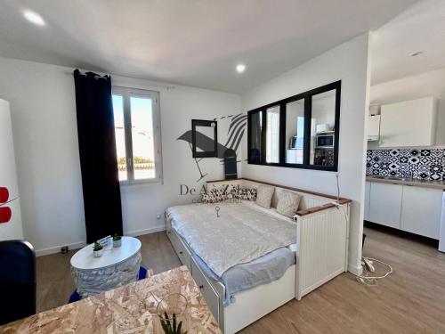 une chambre avec un lit et une table dedans dans l'établissement Le Moderne - Appartement situé en plein centre-ville, à Rochefort