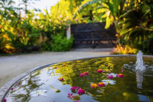 a fountain with flowers on top of a pool of water at Mantaray Siargao in General Luna