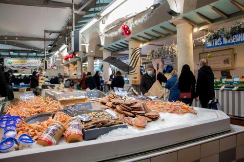 des personnes se promenant autour d'un marché avec des fruits de mer exposés dans l'établissement Le Moderne - Appartement situé en plein centre-ville, à Rochefort