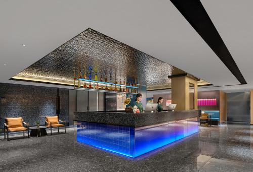 a lobby with a bar with blue lights at Lanwan Hotel - Guangzhou Shamian Island Yongqingfang Branch in Guangzhou