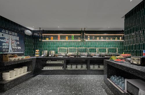 a kitchen with green tiled walls and a counter at Lan Wan Hotel - Next to Huangsha Metro St ation -One cup of Free Cockt ail or Harbin Beer Per Room--Cha rgeable Airport Pick-up Service in Guangzhou