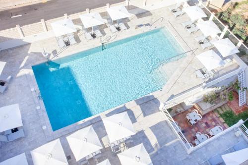 an overhead view of a swimming pool with white umbrellas at BQ Apolo Hotel in Can Pastilla