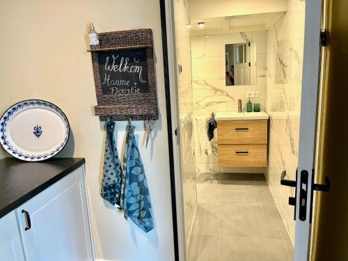 ein Badezimmer mit Waschbecken und ein Schild an der Tür in der Unterkunft B&B Schipperspad in Tolkamer