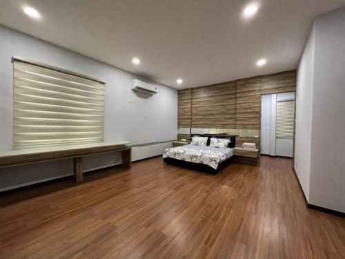 a bedroom with a bed and a wooden floor at 1717 Bintulu Homestay 11 in Bintulu