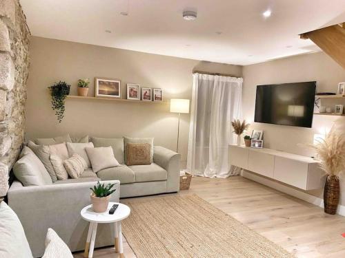 sala de estar con sofá y TV de pantalla plana en MEILA COTTAGE LUXURY COASTAL RETREAT, en Cubert