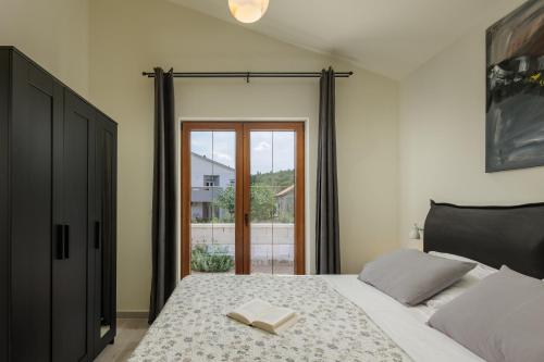 um quarto com uma cama com um livro em Villa Alora em Pridraga