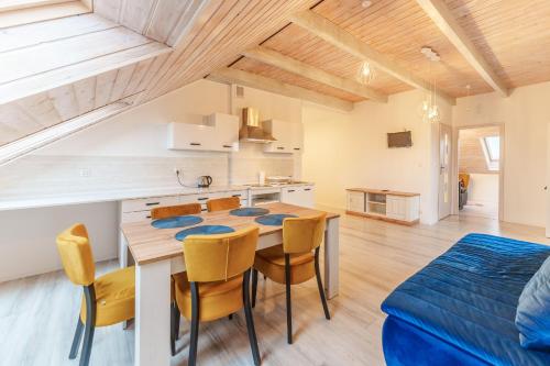 a kitchen and dining room with a table and chairs at Nadmorski apartament XXIV by Holiday&Sun in Grzybowo