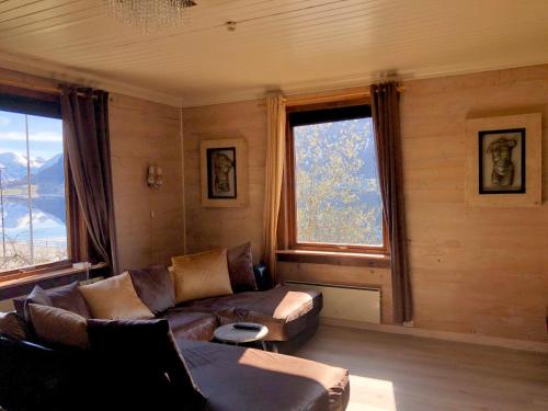 a living room with a couch and two windows at Apartment with lake view in Jølster in Årdal