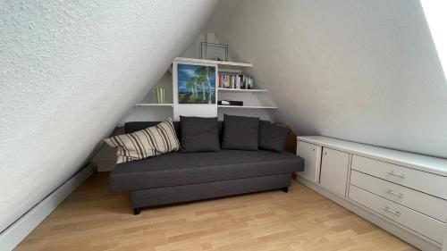 een woonkamer met een bank en een boekenplank bij Apartment über 2 Etagen nahe Messe und Stadion in Dortmund