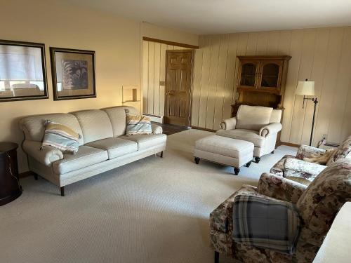 una sala de estar con 2 sofás y una silla en Holiday House, en Mankato