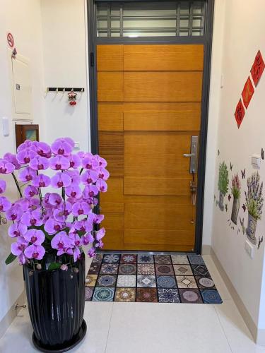 a vase filled with purple flowers in front of a door at 芯之所嚮 in Hualien City