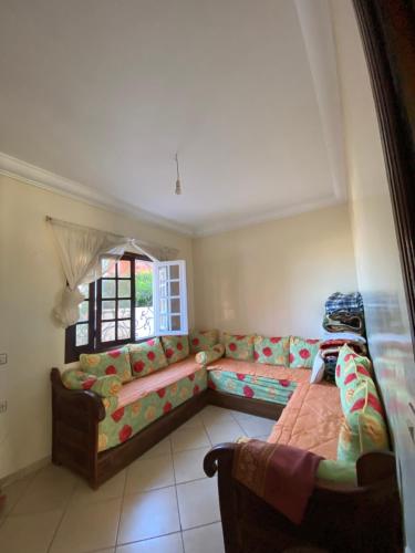 een woonkamer met een bank en een raam bij villa à souiriya kdima in Safi