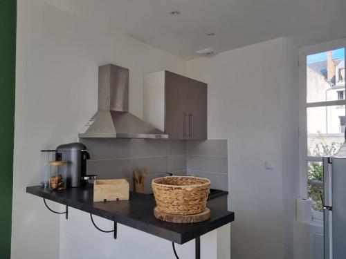 - une cuisine avec un comptoir et un panier dans l'établissement Appartement au cœur d'Orléans en bord de Loire, à Orléans
