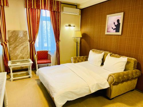 a hotel room with a bed and a chair at Villa & Restaurant Levoslav House in Sibiu