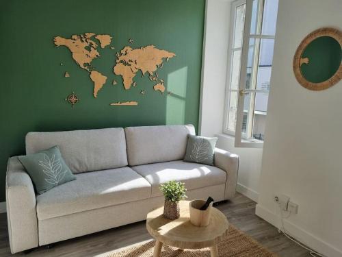 a living room with a couch and a green wall at Appartement centre d'Orléans en bord de Loire in Orléans